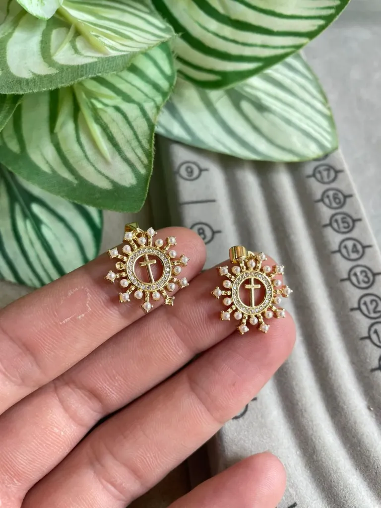 Dije de cruz con perlas.